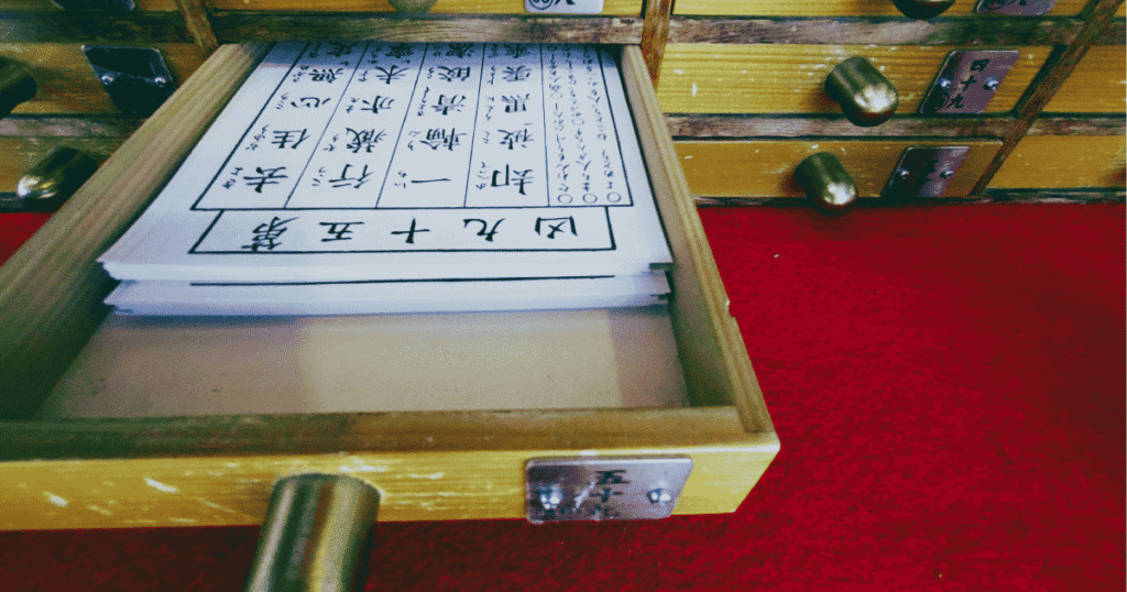 Matching the number on the wooden stick with the drawer to get a fortune paper.