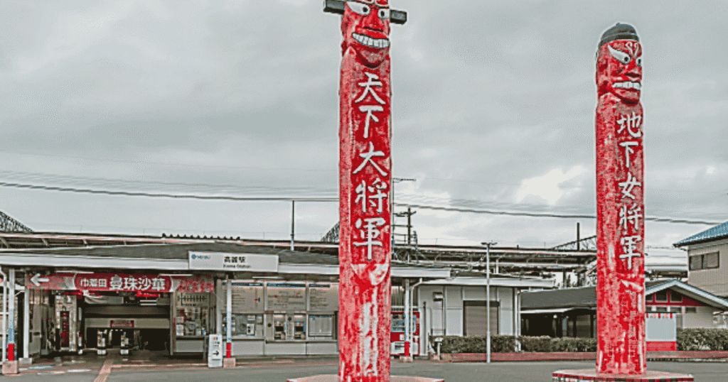 The front of Koma Station with unique wooden monuments in the plaza